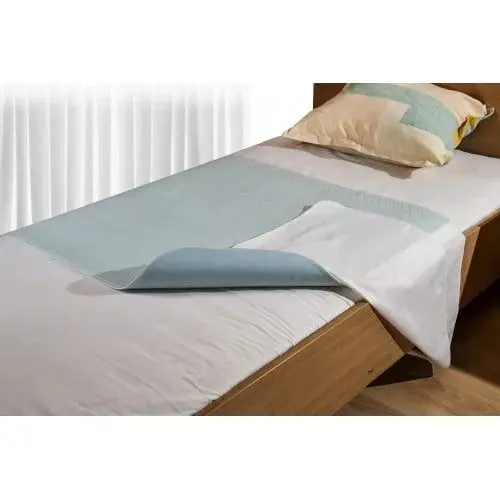 MultiMotion wasbare onderlegger met instopstroken (half omgevouwen op een matras)